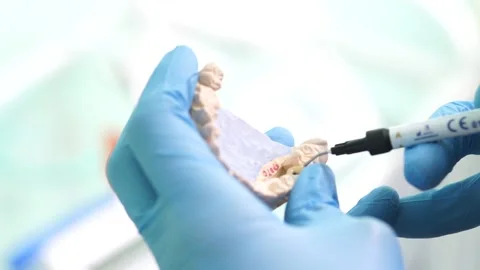 Close up hands dentist makes a denture tooth cleanliness doctor Video stock 137406278