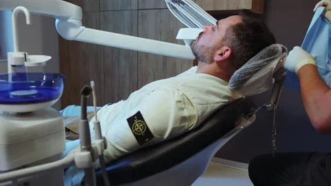 Close up hands dentist preparing patient for the procedure in light dental Stock Footage 232865571