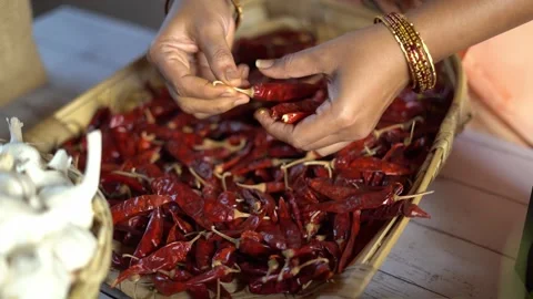 Close up of hands destemming dried red chillies before grinding Stock Footage 340958615