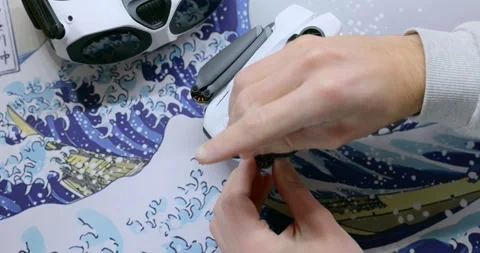 Close-up of hands disassembling and replacing propellers on a compact FPV Stock Footage 345021954