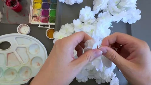 Close up of hands disassembling white artificial flowers from plastic stems Stock Footage 345718857