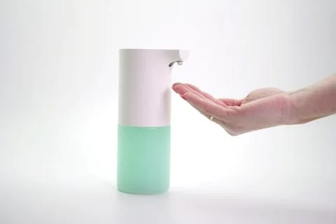 Close-up of hands disinfected with a foam automatic dispenser, isolated Stock Photos