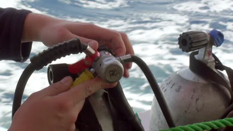Close-up hands of diver prepare aqualung for diving on background of waves. Stock Footage 233514621
