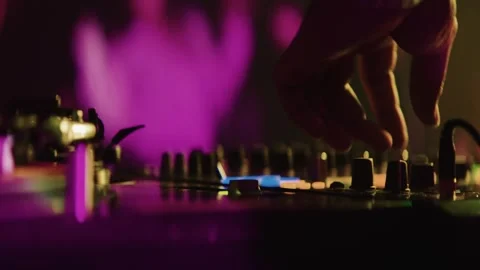Close up hands of dj mixing music on turntable at night party with vibrant .. Stock Footage 337403057