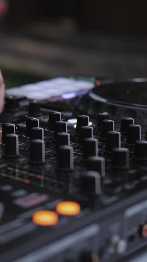 Close-up of the hands of a DJ playing at a wedding or outdoor event, adjusting Stock Footage 311246982