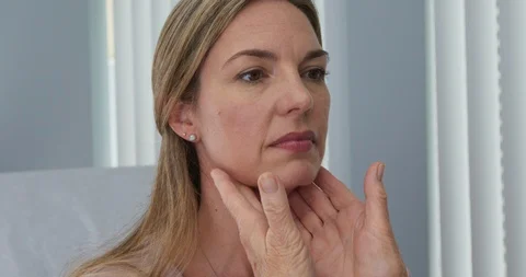 Close up on hands of doctor feeling lymph nodes on female Caucasian patient Stock Footage 102771197
