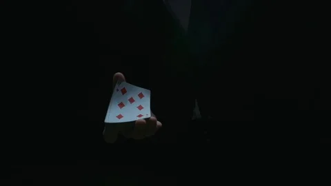 Close-up of the hands of a dressed magician performing a card trick. Cards fly Stock Footage 129359531
