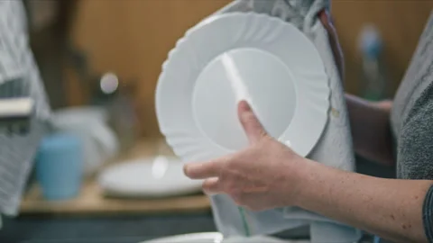 Close-up of hands drying plate with kitchen towel, everyday household routi.. Stock Footage 344579765