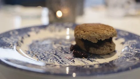 Close up on hands, each pick up homemade scone with cherry jam Stock Footage 78734006