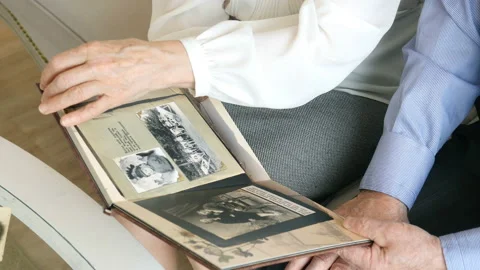 Close-up hands of elderly couple holding a photo album Stock-Footage 89040629