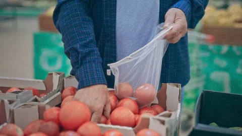 Close-up, hands of an elderly man pensioner picking and putting vegetables in an Stock Footage 250197287
