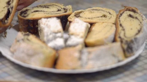 Close-up, Hands of an Elderly Woman Put on a Plate A Slice of Baked Roll with Stock Footage 87956480