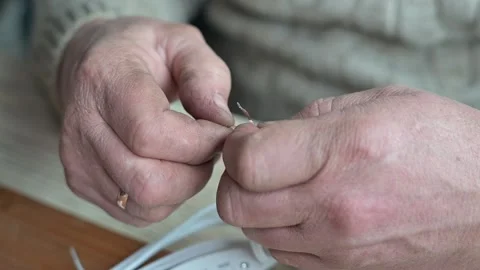 Close-up of hands engaged in wire stripping, showing the careful removal of Vidéo 337111216
