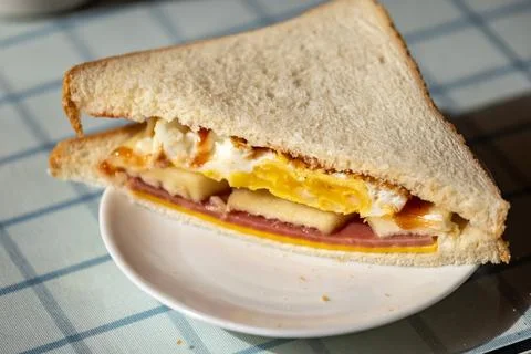 Close-up of hands enjoying a sandwich, a backlit breakfast scene, a documen.. Stockfoto's
