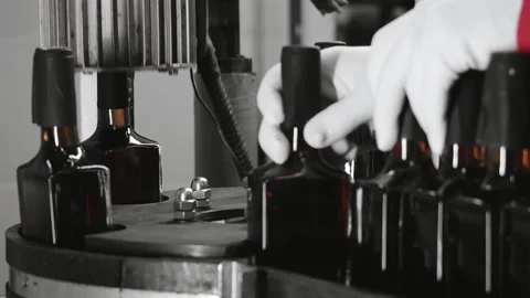 Close-up of the hands of a factory worker putting plastic caps on bottles. Stock Footage 288411226