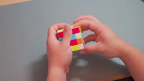 Close up of hands fast twisting colorful magic cube puzzle Video stock 337688099