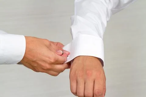 Close Up of Hands Fastening a Cufflink on a White Dress Shirt Sleeve Stock Photos
