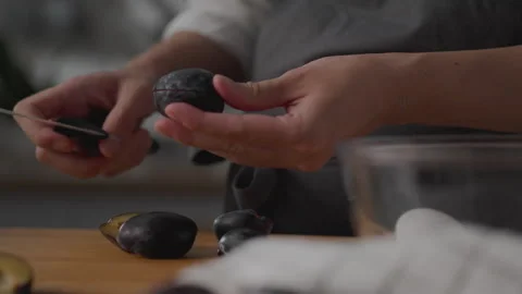 Close-up of hands female farm worker holding fresh ripe plums in kitchen whi Stock Footage 250528145