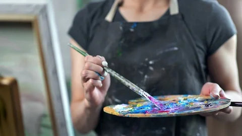Close-up hands of female professional painter mixing color oil acrylic paint on Stock Footage 109045080