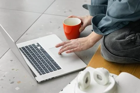 Close-up of hands, female student using laptop and drinking coffee. Stock Photos