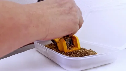 Close Up Hands Filling Yellow Cigarette Rolling Machine with Tobacco Vídeo Stock 346067522