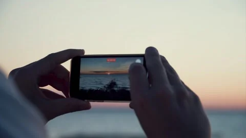 Close-Up Of Hands Filming Sea Sunset With Smartphone. Video stock 255080101