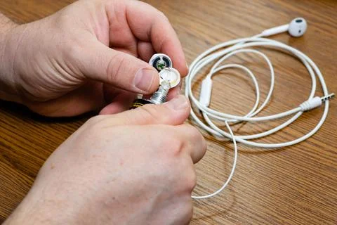 Close up of hands fixing white wired earphones Stock Photos