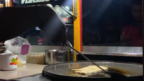 Close-up of hands flipping through martabak fried on a pan Stock Footage 292907840