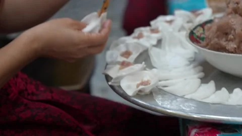 Close-Up of Hands Folding Fresh Dumplings on Metal Tray, Vietnam Stock Footage 329947362