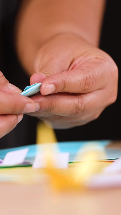 Close Up of Hands Folding Light Blue Origami Paper at a Table Stock Footage 327177127