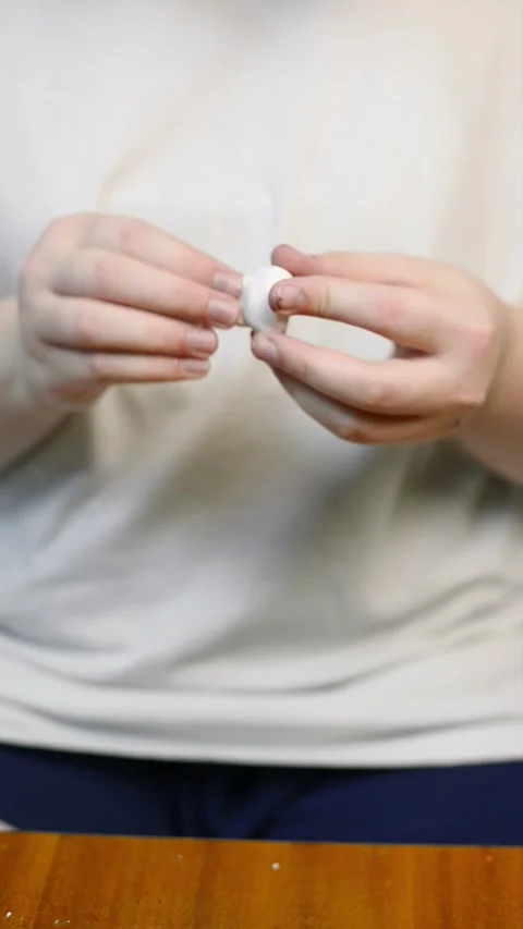 Close up of hands forming a white polymer clay element on a wooden table Vídeo Stock 342907549