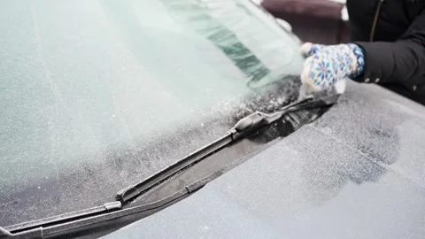 Close-up of hands freeing stuck windshield wiper blades and scraping frost near Stock-Footage 327528238