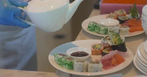 Close up of hands with gloves preparing and serving japanese sushi. Chef pouring 스톡 동영상 154932808