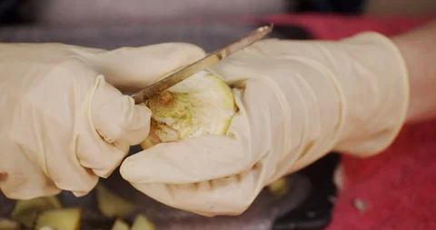 Close up of hands with gloves while preparing artichokes Stock Footage 128931988