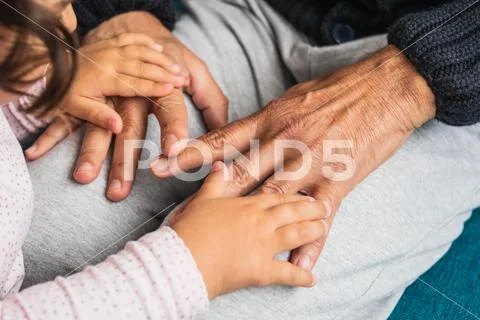 Close-up of the hands of a grandfather and his granddaughter. Stock Photos