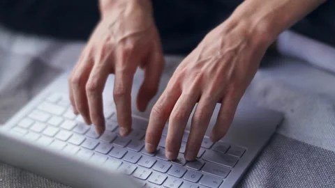 Close-up of the hands of a guy typing on a laptop. Indoors. Stock Footage 154715633