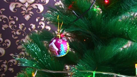Close-up hands hang a toy with a painted house on the Christmas tree. Stock Footage 145575773