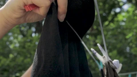 Close up hands Hanging Up Wet Laundry On Clothesline, sunny Stock Footage 131629819