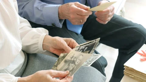 Close-up, hands of happy caucasian elderly couple watching old photos Stockbeeldmateriaal 89037660