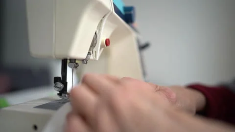 Close up of Hands of Hardworking European Elderly Woman, stitching fabric using Stock Footage 148333877