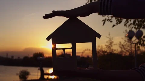 Close-up hands hold the house at sunset. Stock Footage 108308816