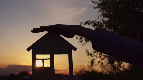 Close-up hands hold the house at sunset. Stock Footage 108929959