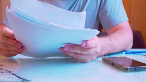 Close-up of hands holding and flipping through a stack of documents Stock Footage 336693522