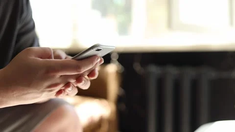 Close-up of hands holding and typing on a smartphone indoors Stockbeeldmateriaal 342280517