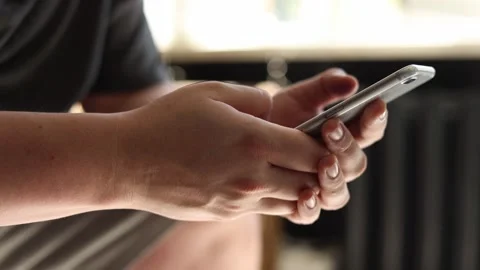 Close-up of hands holding and using a smartphone with fingers scrolling Stockbeeldmateriaal 342280537