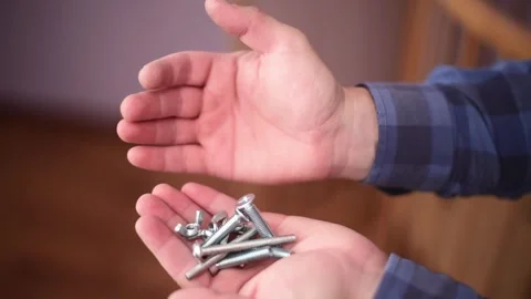 Close-up hands holding bolts and nuts.Сarpenter's tools. Horizontal 4k footage Stock Footage 244922502