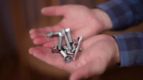 Close-up hands holding bolts and nuts.Сarpenter's tools. Horizontal 4k footage Stock Footage 245543150