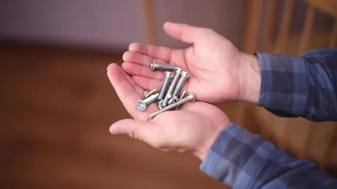 Close-up hands holding bolts and nuts.Сarpenter's tools. Horizontal 4k footage Stock Footage 247132233