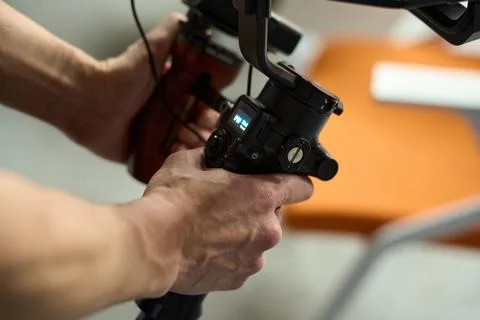 Close-Up of Hands Holding Camera Stabilizer for Filmmaking Stock Photos