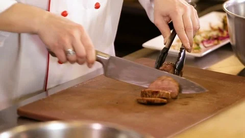 Close up on hands holding cooked meat on a cutting board, slicing cooked meat Stock Footage 74717089